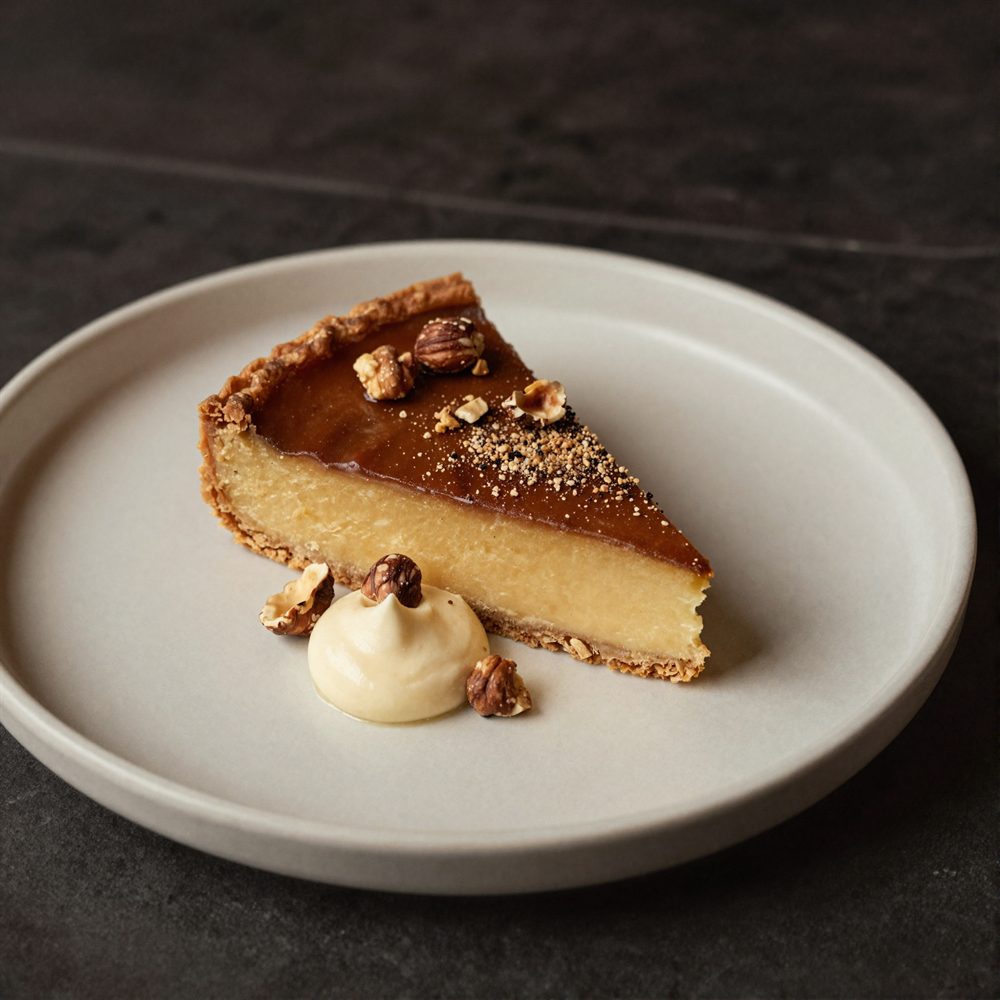 Burnt honey and brown butter tart with crème fraîche and hazelnuts